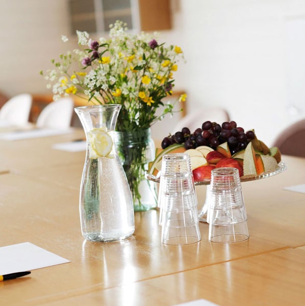 bord med frukt, blomsterbukett og glass med vann